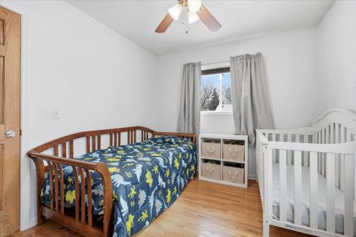 Additional view of the bedroom showing hardwood flooring, and functional layout with space for multiple furniture options.