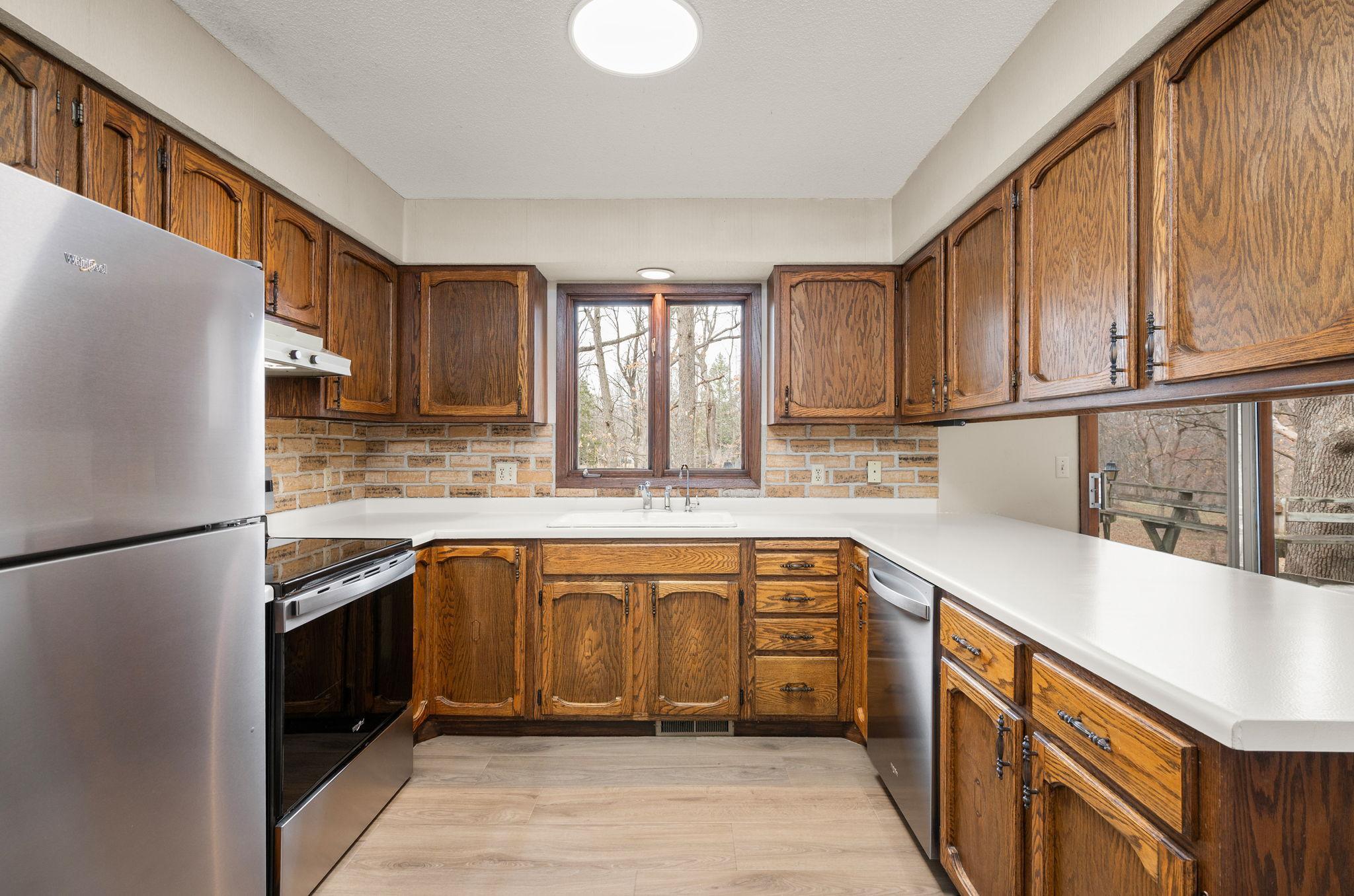 Kitchen has new flooring and new stainless steel appliances and a breakfast bar with informal dining room and access to huge wrap-around deck