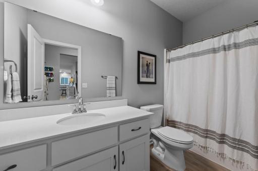 Main Floor Full Bathroom next to Main Floor Bedroom - with Corian Countertop, slow-close drawers, and LVT