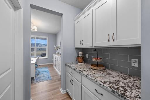 Butler's Pantry off of the Kitchen with Walk-in Pantry. Tile backsplash, slow-close drawers, Quartz countertops.