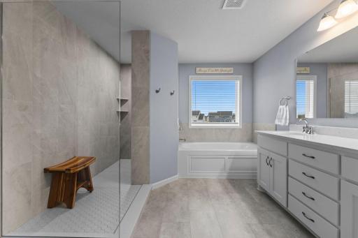 Owner's Suite Bathroom with Walk-through Shower, Soaking Tub, Window, Tinted Window, Corian Countertop, Slow Close Drawers, LVT, Built-In Shelving &Tile Surround in Shower