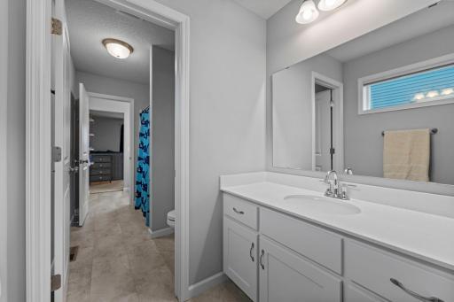 Jack and Jill Bathroom with Corian Countertops, slow close drawers, window, LVT