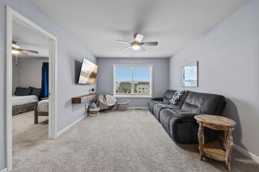 Upper-level loft with tinted window, built-in custom shelf, ceiling fan, knockdown ceilings throughout