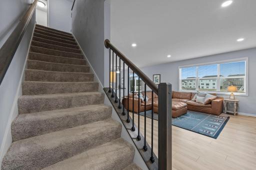 Half wall with iron rod balusters on staircase opening up to the living room