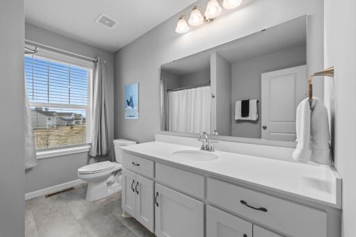 Upper-level Full Bathroom with corian countertops, slow close drawers, tinted window, & LVT flooring