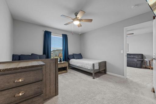 Upper-level 3rd bedroom with built-in shelves, ceiling fan, custom window treatments, Jack and Jill Bath