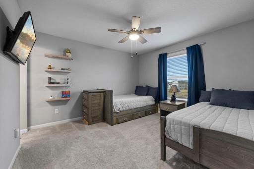 Upper-level 3rd bedroom with built-in shelves, ceiling fan, custom window treatments, Jack and Jill Bath