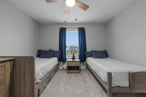 Upper level 3rd bedroom with built ins, ceiling fan, custom window treatments, and tinted window!