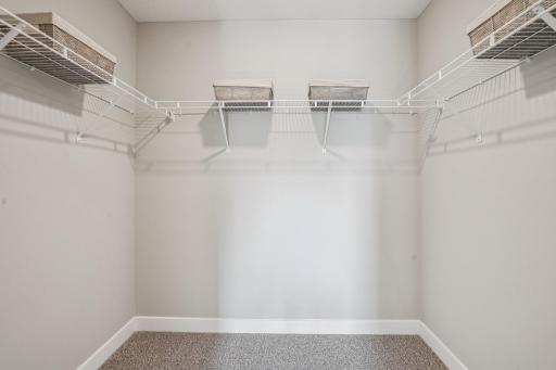 An oasis of its own, the primary suite offers the perfect escape. There's immediate access to a private bathroom that features dual sinks and a large shower. Photo is of model home. Colors and options may vary.