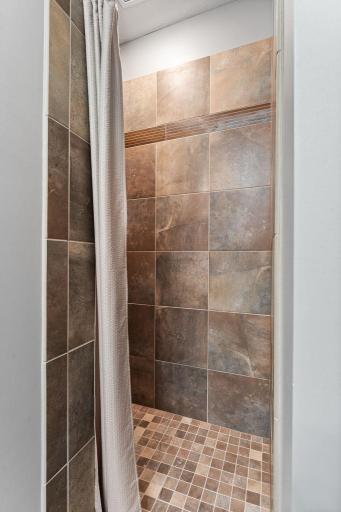 Walk in primary shower with elegant tile.