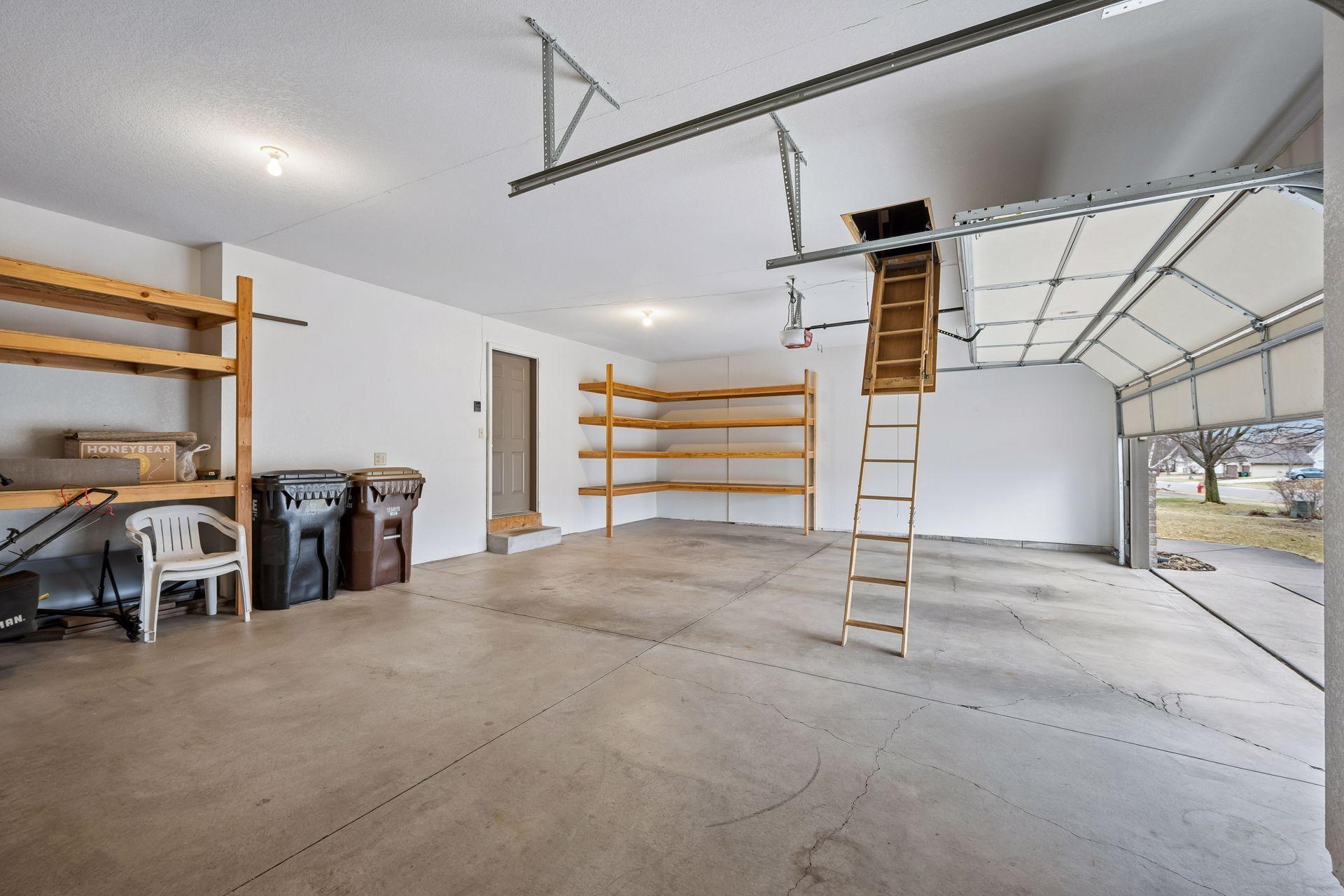 Pull down ladder in garage with lots of storage above