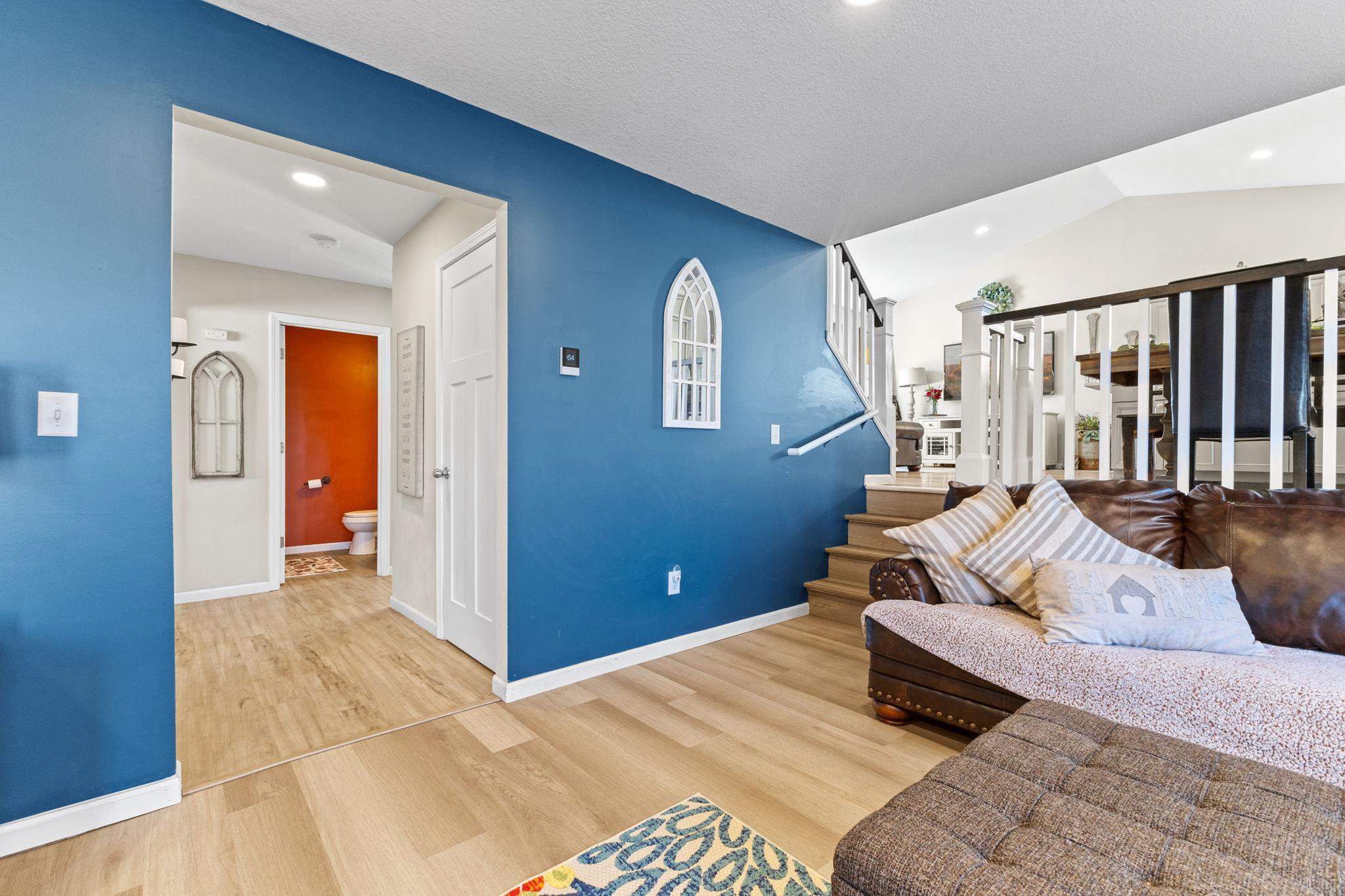 A look down the hallway leading to the main level bedroom, bathroom, and flowing naturally back to the foyer.