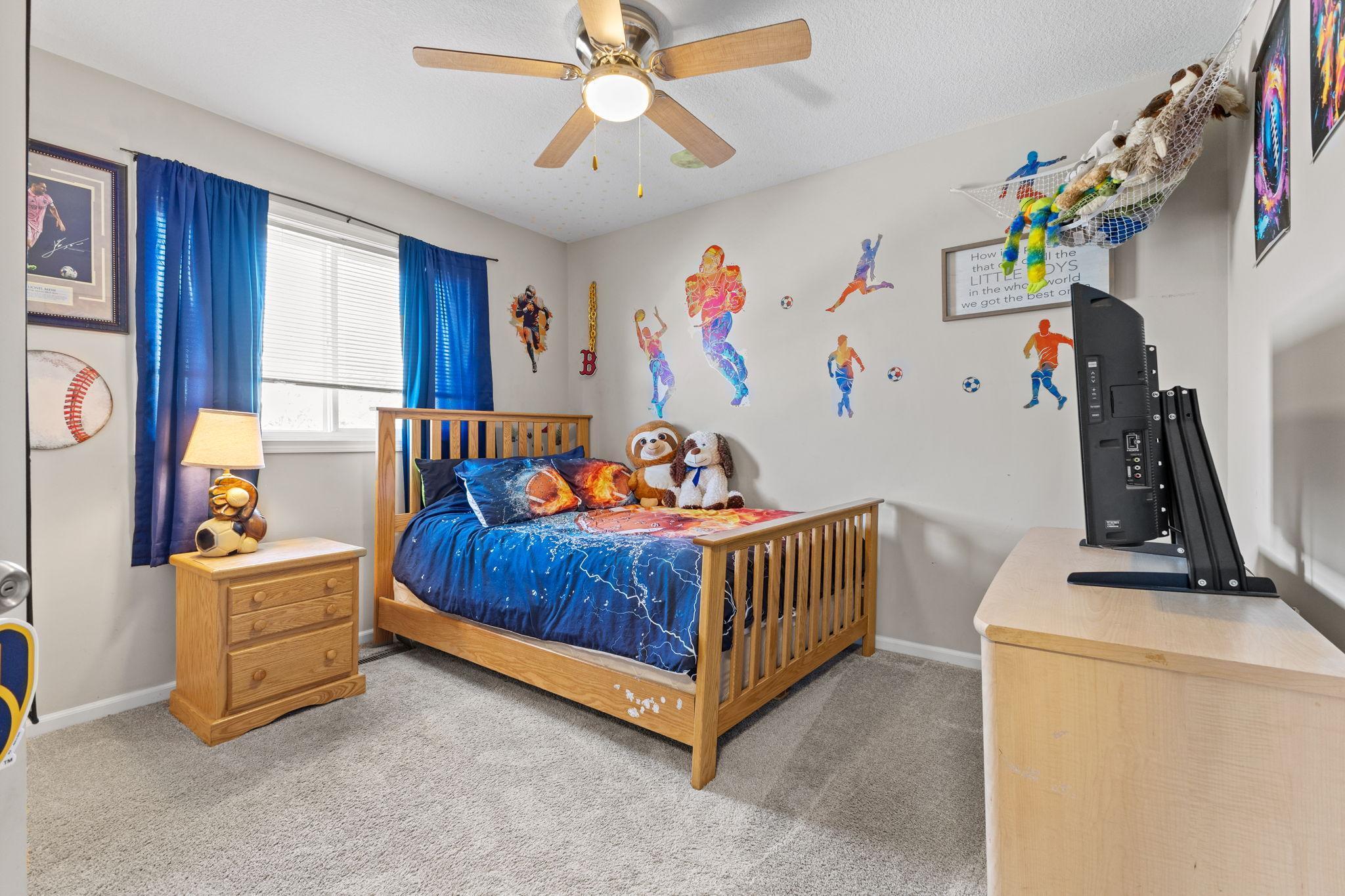 Second upper level bedroom also with neutral tones, plush carpeting, and a ceiling fan.
