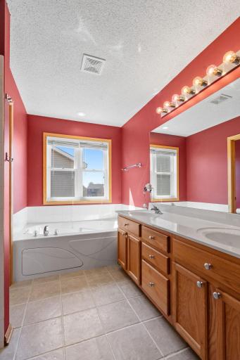 Primary bathroom with jetted tub, double vanity, and separate shower.
