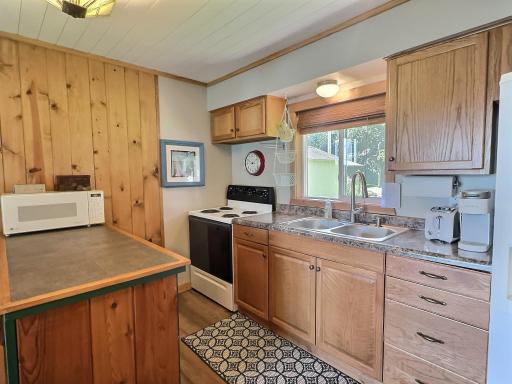 The kitchen in this cabin is warm and welcoming, featuring knotty pine accents and classic oak cabinetry.