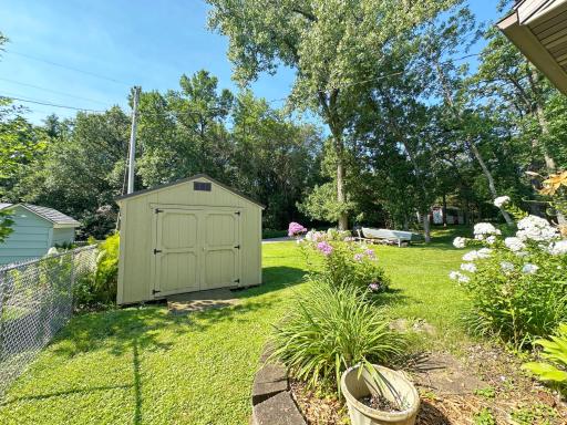 A storage shed adds convenience, while the level lot features gorgeous and colorful perennials throughout.