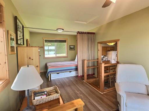 The layout combines a relaxed sitting area with an adjacent sleeping space, separated by a curtain for privacy.