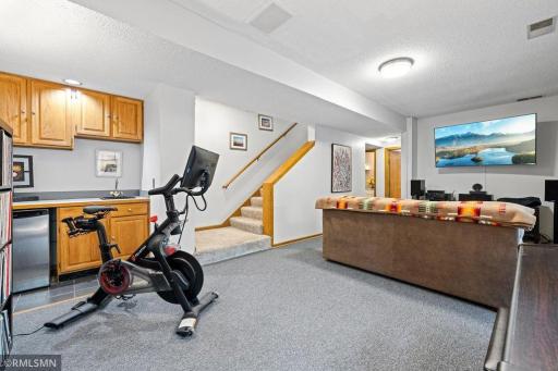 This photo shows the layout of the walkout lower level Family Room. However, the current brand new carpet is lighter in color. Note the inviting, opened-up stairway.