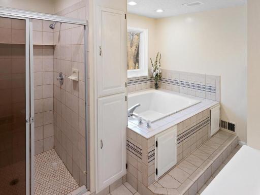 A wallk-in ceramic tiled shower and jetted tub along with two linen closets and newer toilet complete the primary bathroom.
