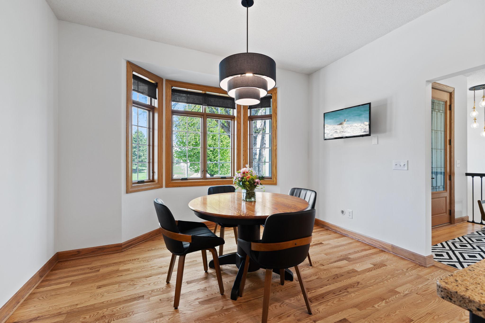 The informal dining space features large windows that fill the room with natural light.