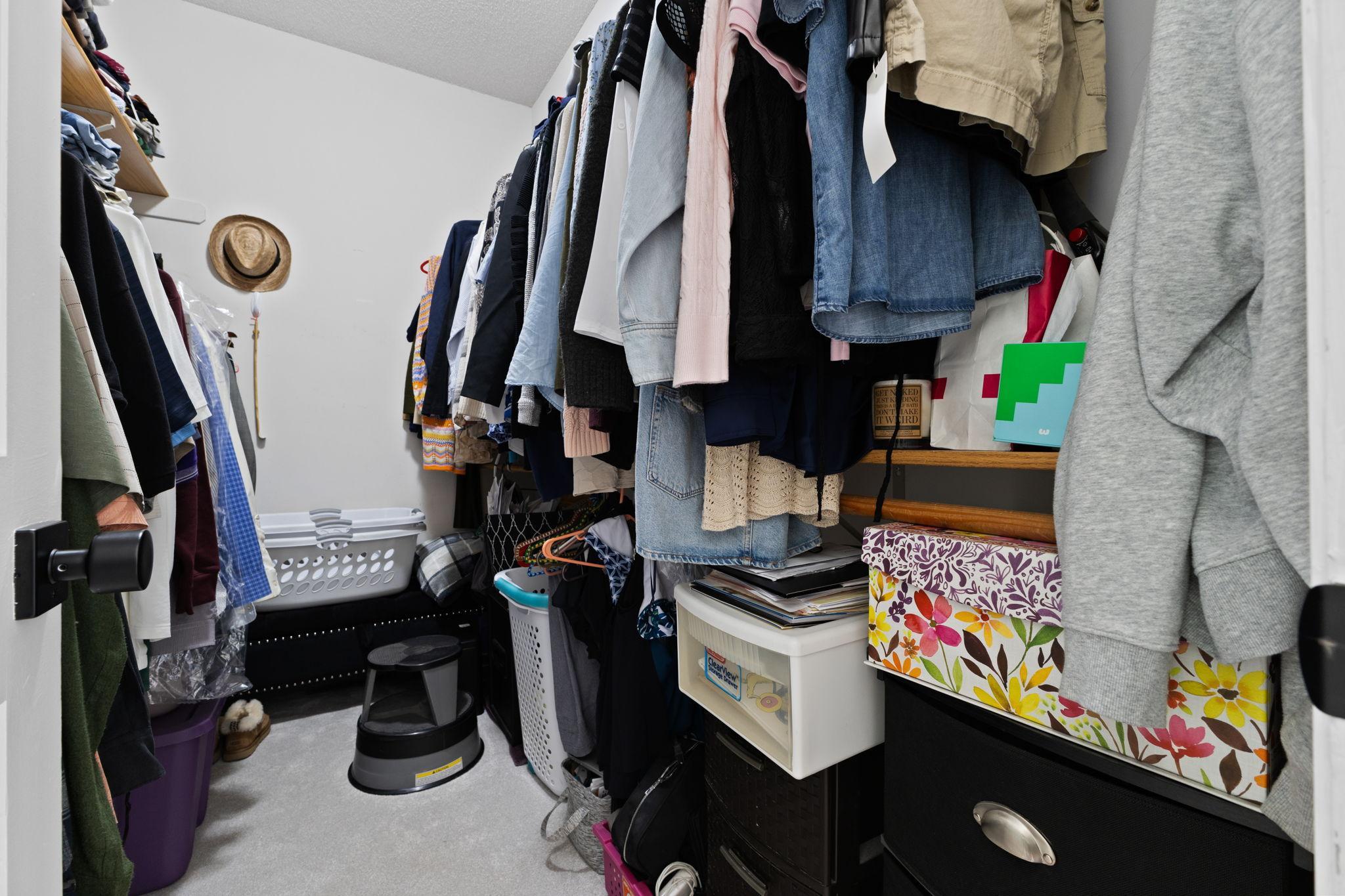 Spacious walk-in closet emphasizes tidiness with storage solutions for all your clothing and accessories.