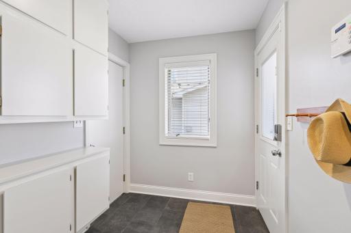 Spacious mudroom with storage cabinetry and direct access to the garage and backyard.