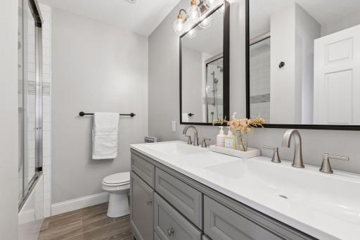 Thoughtfully updated upper level full bathroom showcasing ceiling-height tile, a glass shower enclosure, and a built-in niche for both style and function.