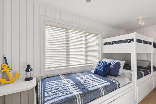 What a fun bedroom featuring an additional bunk roomâperfect for kids, guests, or lakehouse sleepovers!