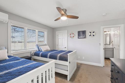 This cheerful bedroom shows the functionality with trundle beds and a connected bunk room, creating a versatile space with plenty of room for kids, friends, or lake house sleepovers.