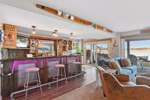 This lakehouse lower level is built for fun, with a family room and bar/entertainment area that opens directly to lakeside living and views.