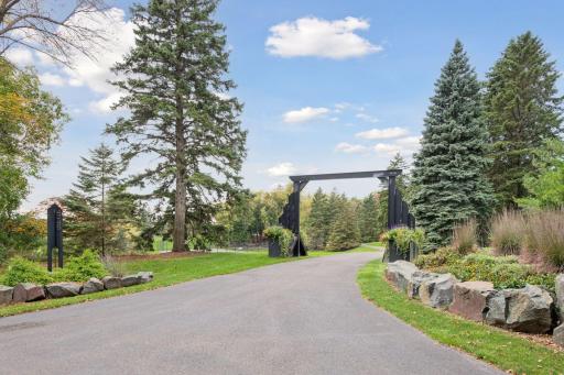 A beautifully landscaped entrance greets you along a treelined drive to home.