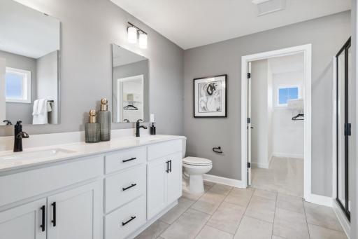 (Photo of decorated model, actual home's finishes will vary) An extension of the primary bedroom, this private and spacious bath contains a double-vanity, a soaking tub and a separate shower.