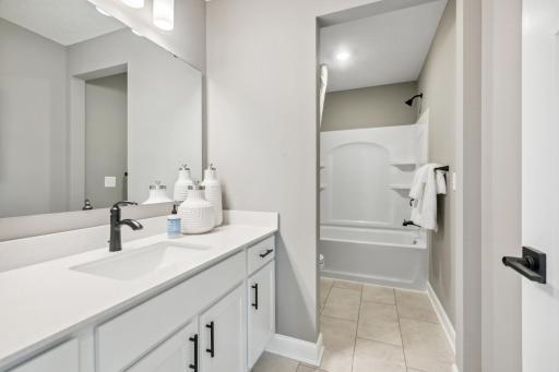 (Photo of decorated model, actual home's finishes will vary) Featuring a double-vanity, this secondary bath is sure to keep everyone moving during those busy mornings.