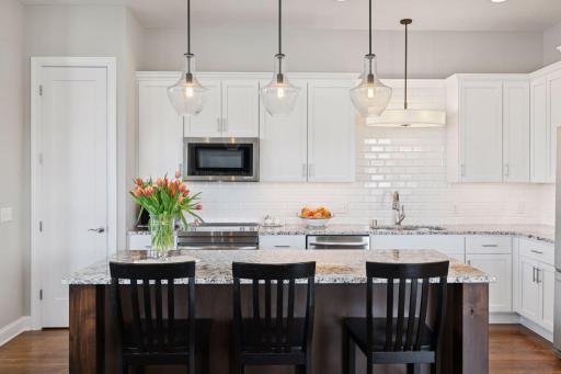 Angle that appreciates the backsplash throughout with great overhead lighting to highlight the kitchens beautiful features.