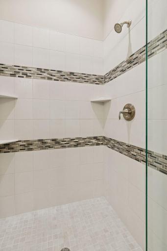 Walk-in shower with a lovely tile design.