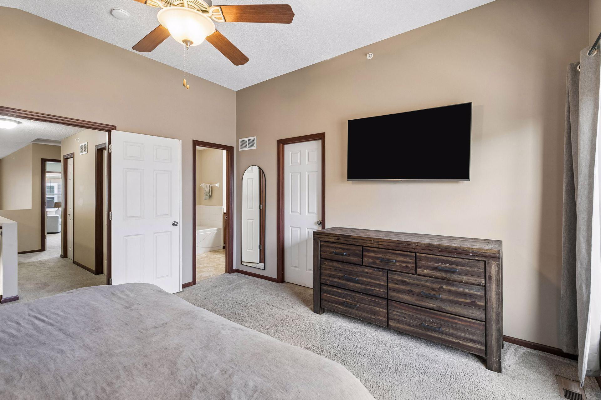 Spacious primary bedroom with vaulted ceiling, walk-in closet, and walk-through access to full bathroom