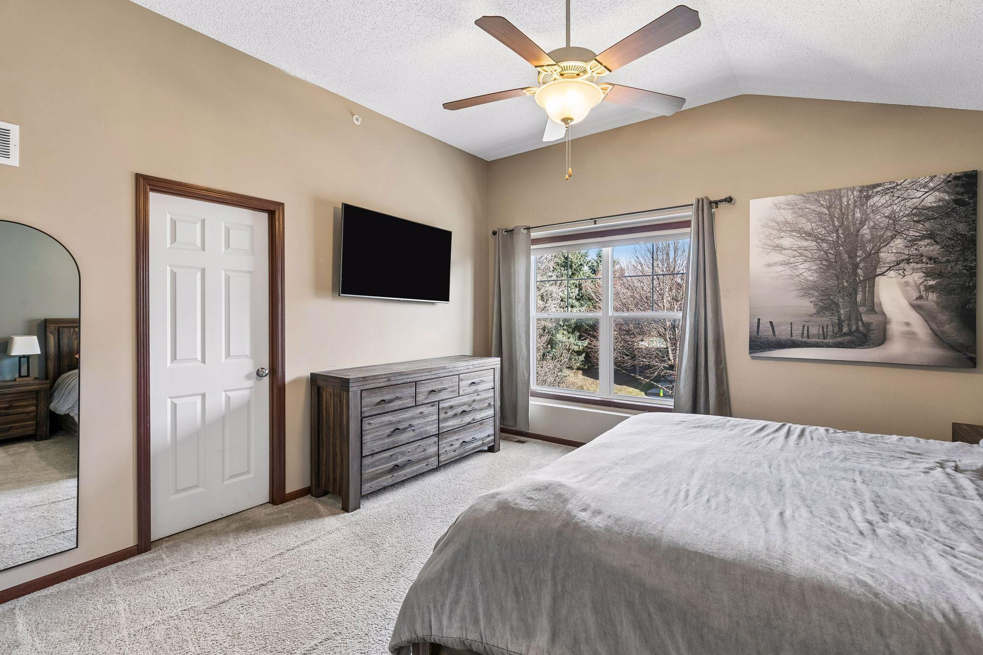Spacious primary bedroom with vaulted ceiling, walk-in closet, and walk-through access to full bathroom