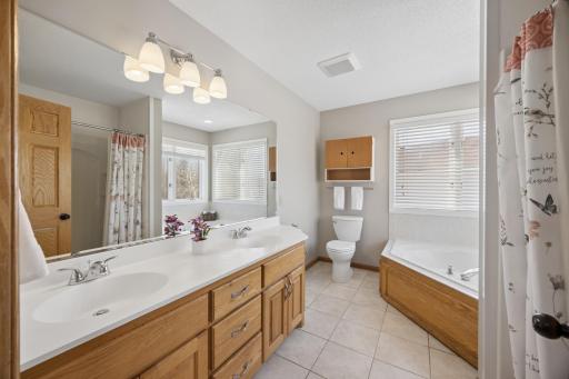 The primary bathroom features a double sink vanity and large mirror. Freshly painted!