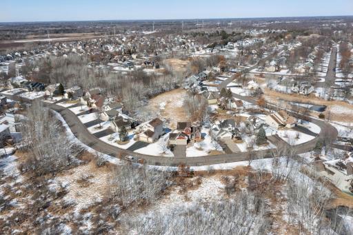 Aerial photo during winter of the neighborhood on the front side of the home. Note the winding streets and established trees adding to the natural beauty of the neighborhood.