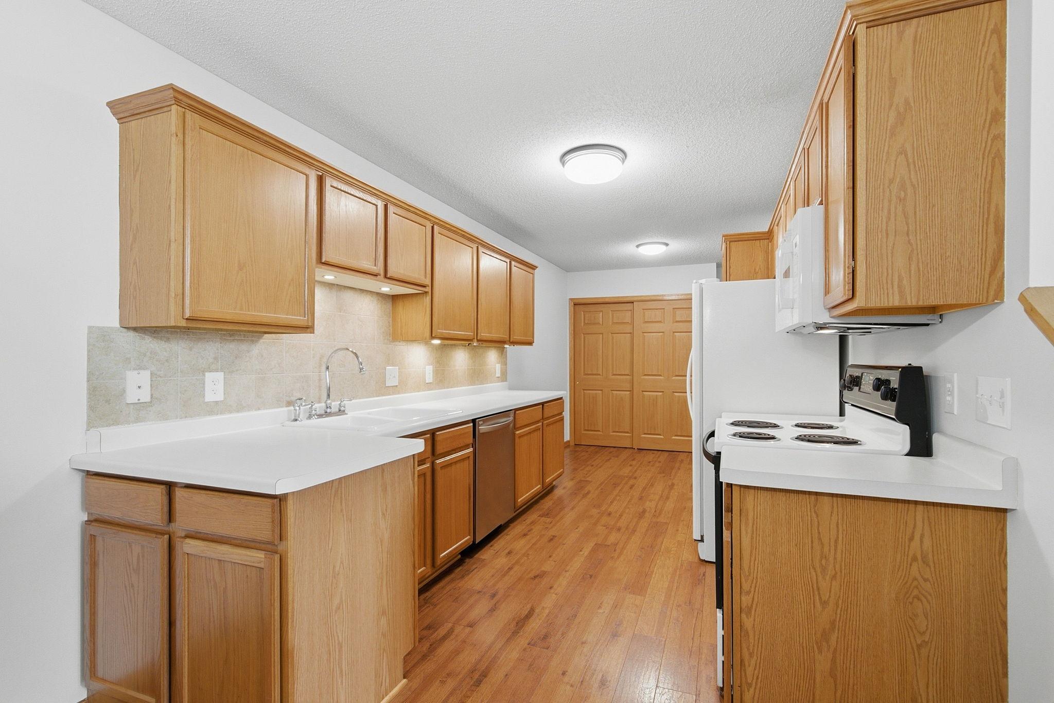 Kitchen features abundant cabinets, under-cabinet lighting, porcelain sink, large pantries. Appliances include Whirlpool side-by-side refrigerator with water & ice dispenser, range, new built-in microwave (2026), LG stainless dishwasher, disposal.