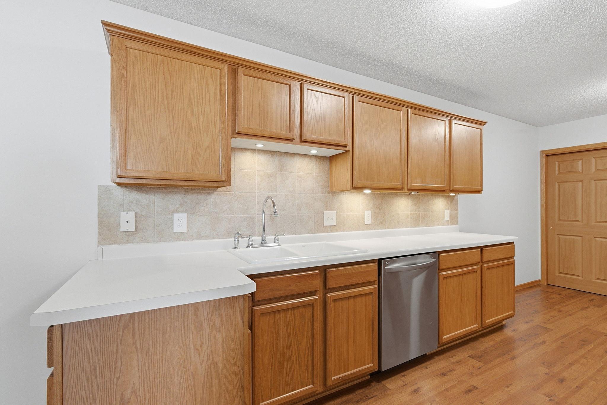 Kitchen features abundant cabinets, under-cabinet lighting, porcelain sink, large pantries. Appliances include Whirlpool side-by-side refrigerator with water & ice dispenser, range, new built-in microwave (2026), LG stainless dishwasher, disposal.