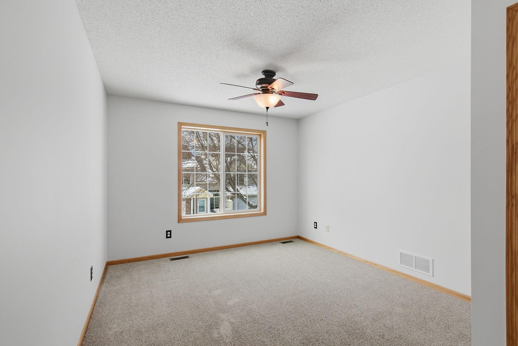 Owner's suite on upper level with ceiling fan and light.