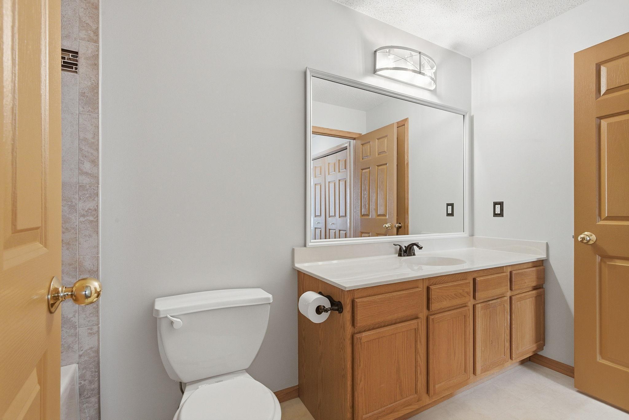 Full bathroom with fresh paint, updated lighting fixture and mirror.