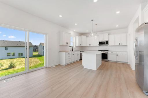 (Photo of an inventory home, actual homes finishes will vary) Soaked in natural sunlight, the home's eat-in dining room has ample space for a dining table located in the heart of the home.