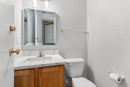 Half Bath on the Main Level with New Quartz Countertops, New Mirror and Lighting. This space also doubles as a Storm Shelter with exterior rated threshold.