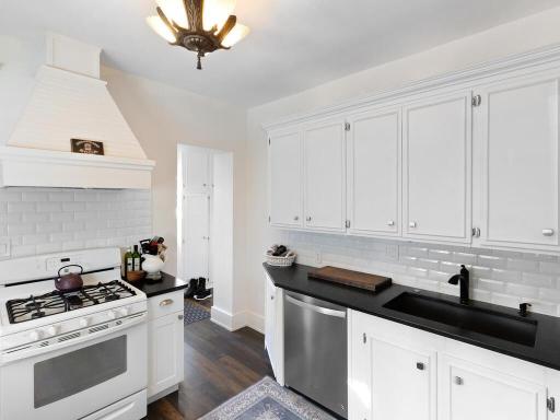 Light-filled kitchen blending modern convenience with timeless detail, complete with subway tile and a beautifully crafted stove hood.