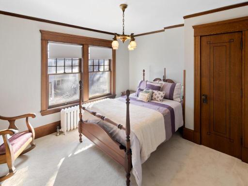 A light-filled bedroom rich in historic charm, highlighted by original wood trim and timeless architectural detail.