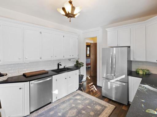 A second look at the kitchen showcasing updated stainless-steel appliances, ample cabinetry, and a bright, functional design.