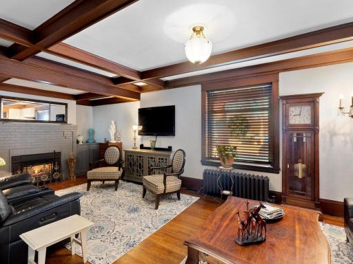 Historic craftsmanship shines in this family room, complete with original masonry fireplace (gas) and preserved floors and ceiling beams.