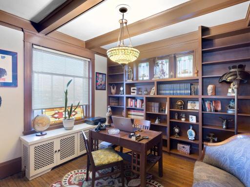 Beautiful home office featuring custom built-ins, original stained-glass accents, and rich woodwork throughout.
